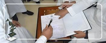 مأذون شرعي في شرق الرياض يراجع بيانات الزوجين على جهاز لوحي قبل إتمام عقد الزواج الرسمي